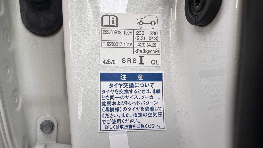 RAV4 50系実車のタイヤ空気圧ラベルで225/60R18の前輪と後輪230kPaを確認している画像